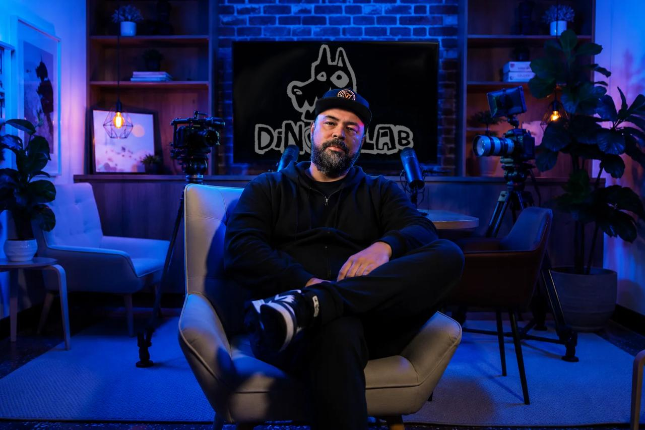 Joseph seated in the Dingo Lab studio, surrounded by production cameras and blue lighting
